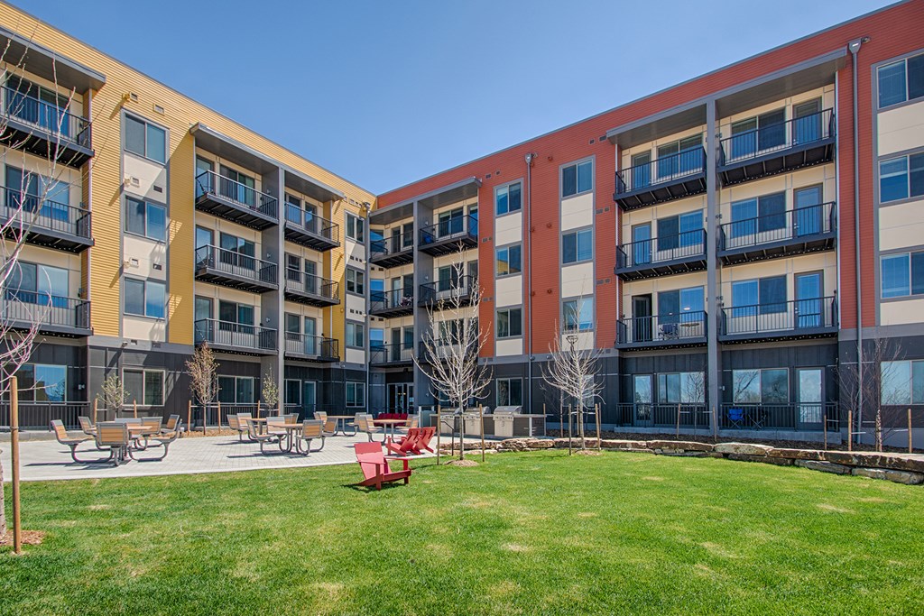 an exterior view of an apartment building with a grassy courtyard
