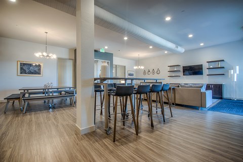 a dining area with bar stools and a kitchen with a dining table and chairs