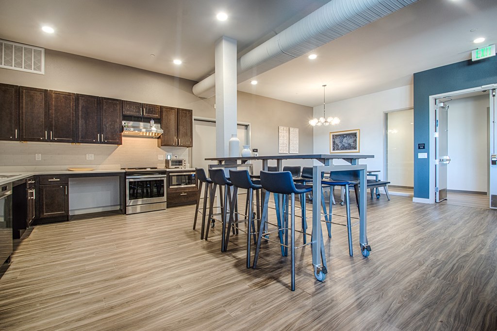 a kitchen with a bar and stools in a living room with a kitchen island