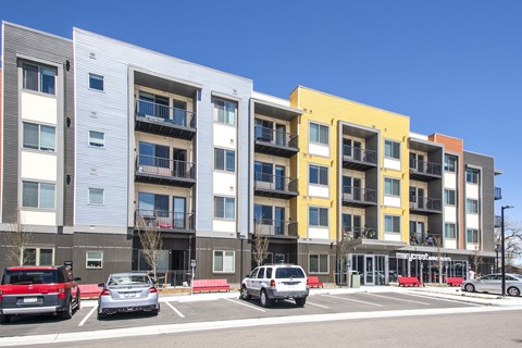 an image of an apartment building with cars parked in front of it