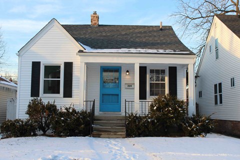 a white house with a blue door in the snow