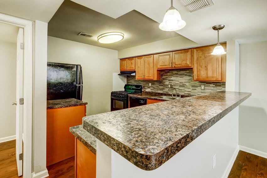 a kitchen with granite countertops and a black refrigerator