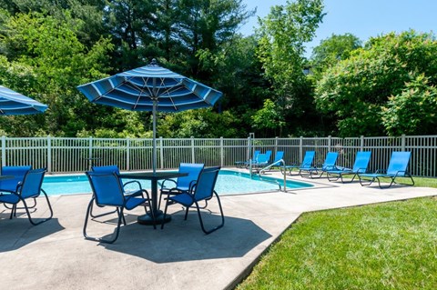 our swimming pool is equipped with a table and chairs and umbrellas