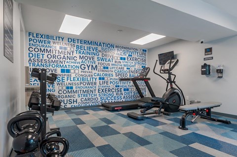 a gym with weights and a wall with words on it