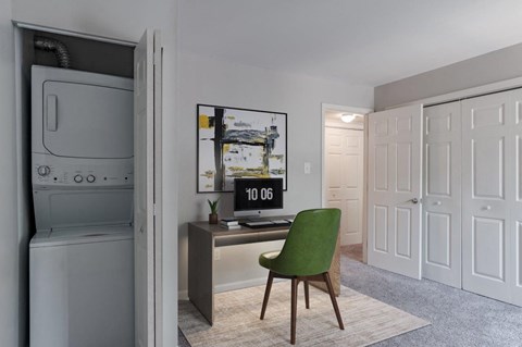 a home office with a green chair and a desk with a computer