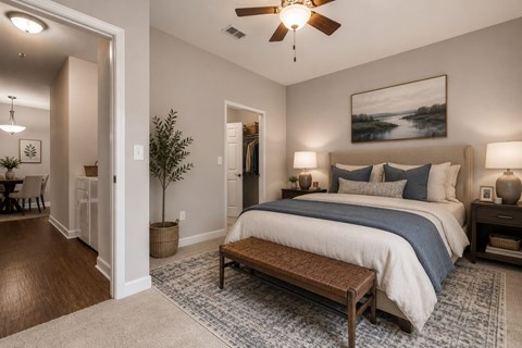 A bedroom with a large bed and a ceiling fan.