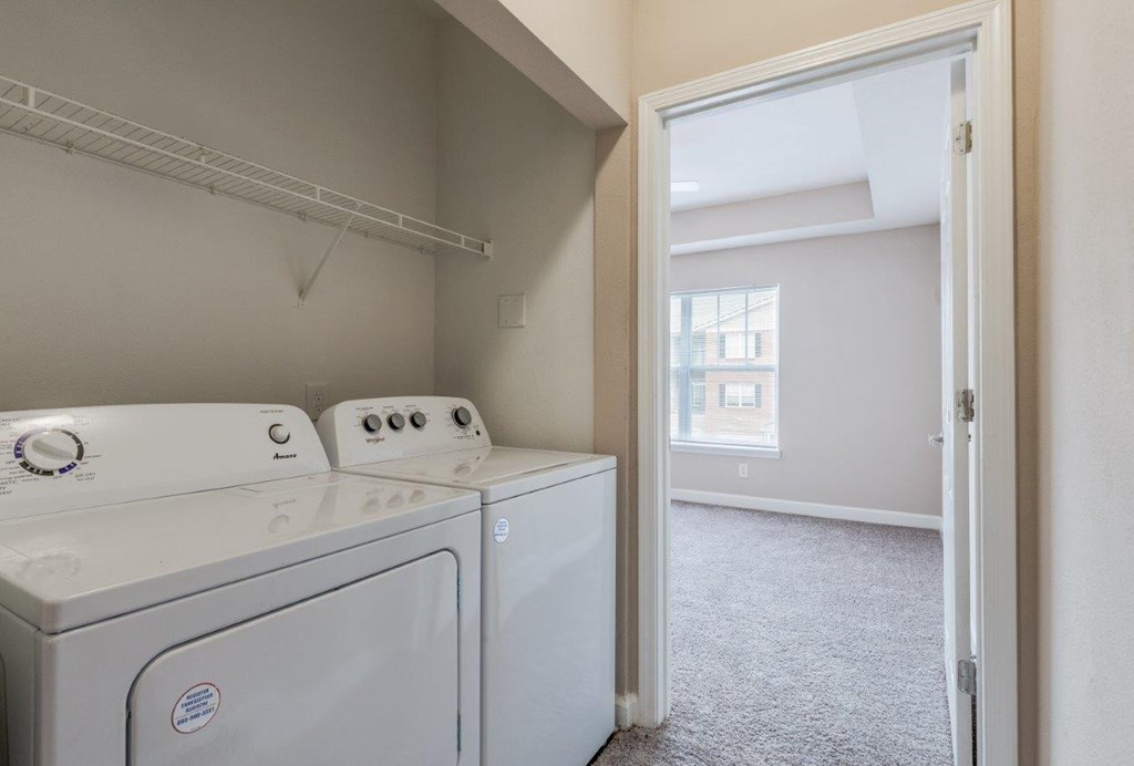 an empty laundry room with a washer and dryer in it