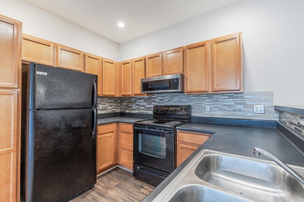 a kitchen with black appliances and wooden cabinets