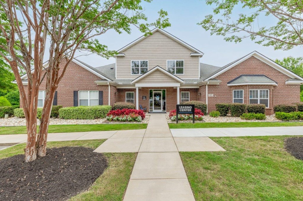 a brick house with a sidewalk in front of it