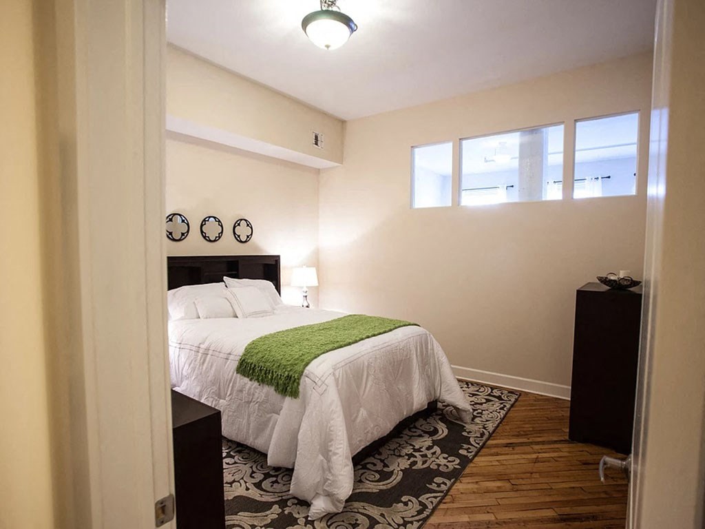a bedroom with a white bed and a green blanket