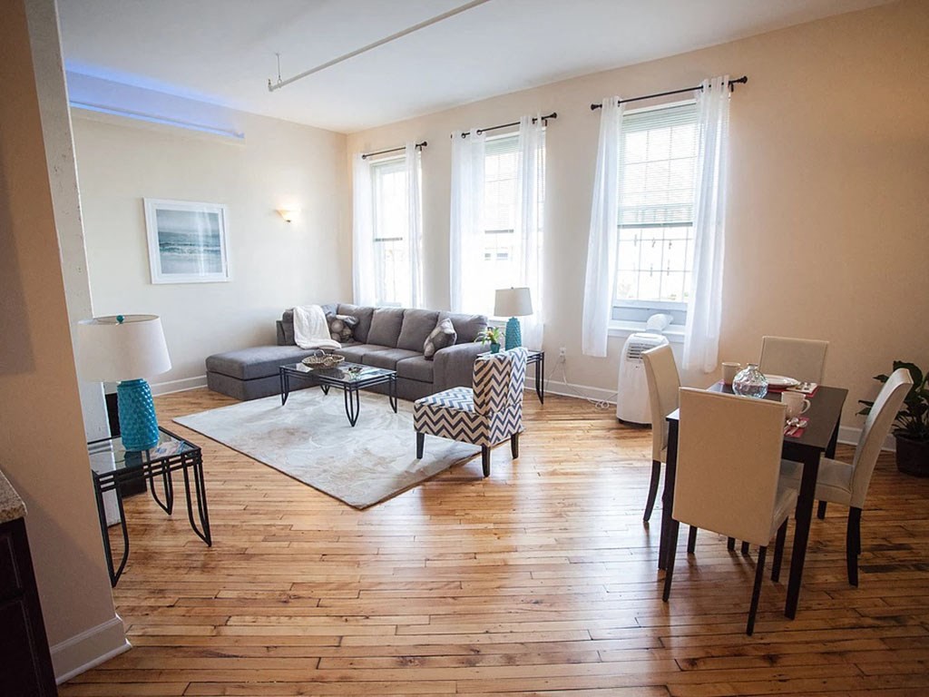 a living room and dining room with a wood floor