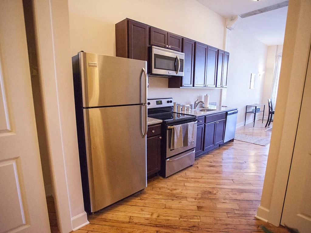 a kitchen with stainless steel appliances and a wooden floor