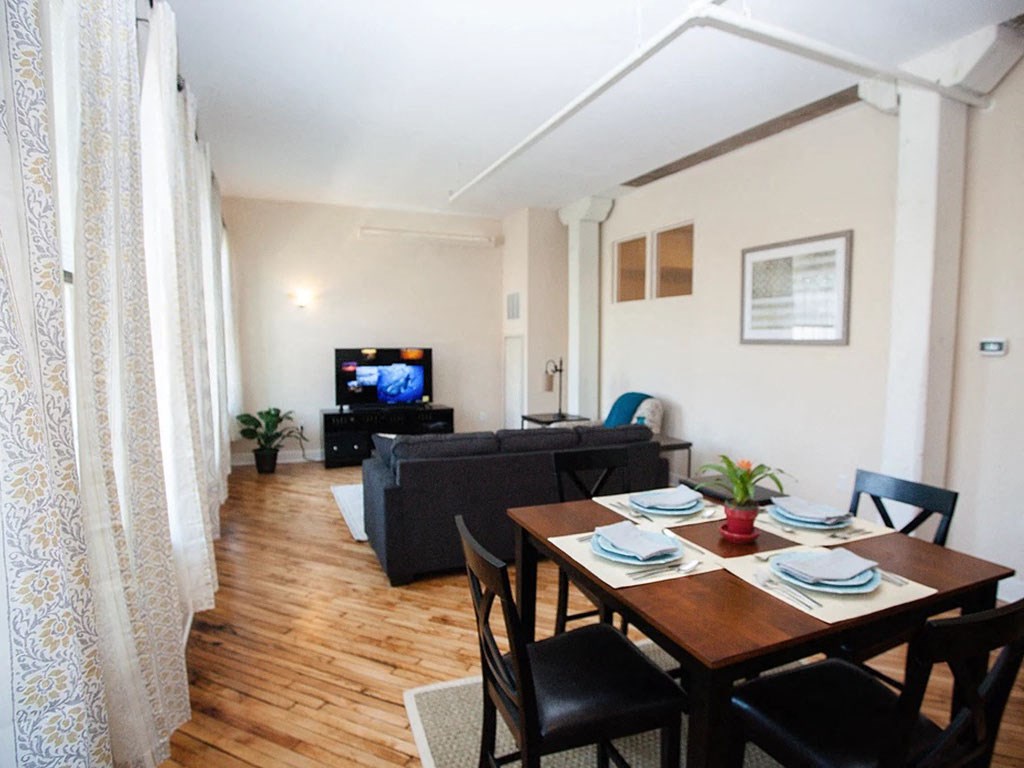 an image of a living room and dining room with a tv