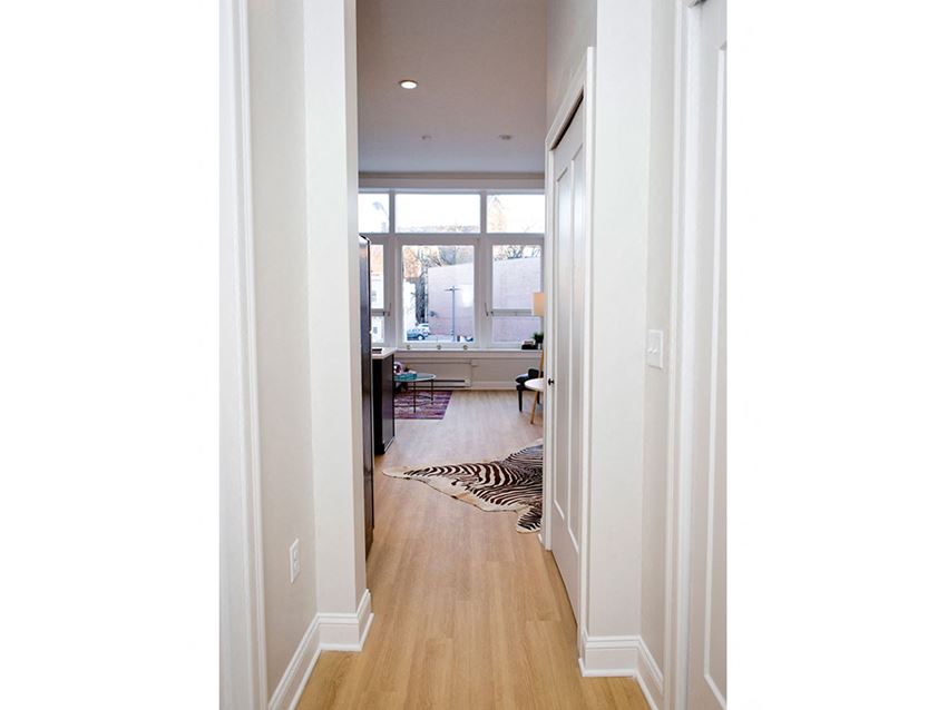 the view from the hallway into the living room and kitchen of a new home