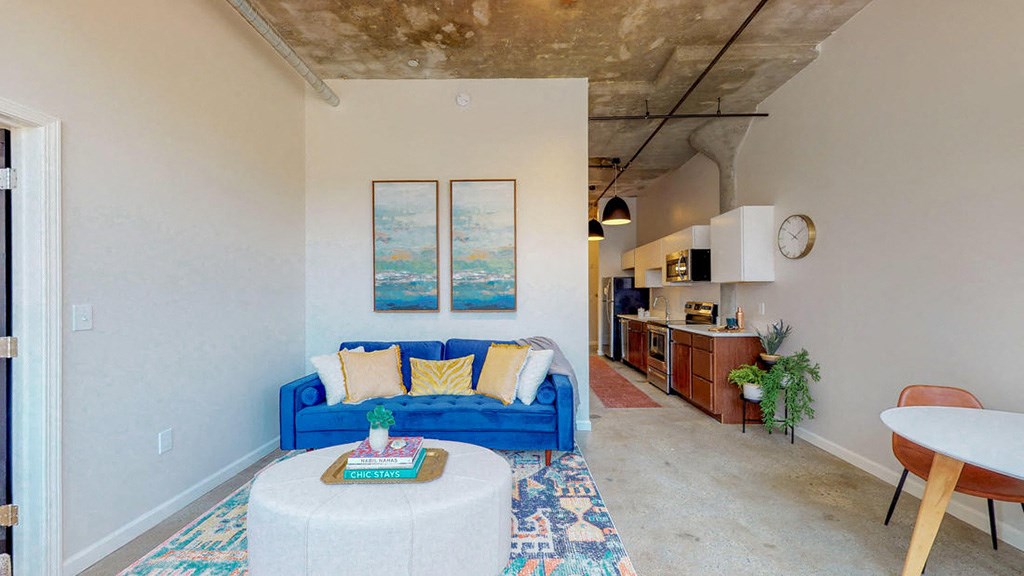 a living room with a blue couch and a white table