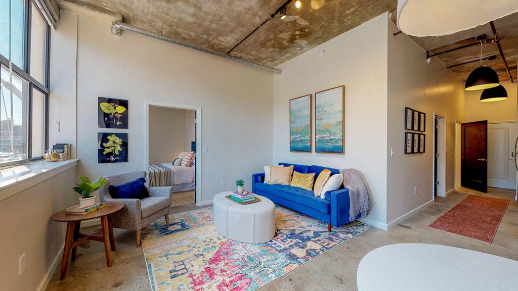 a living room with a blue couch and a white table