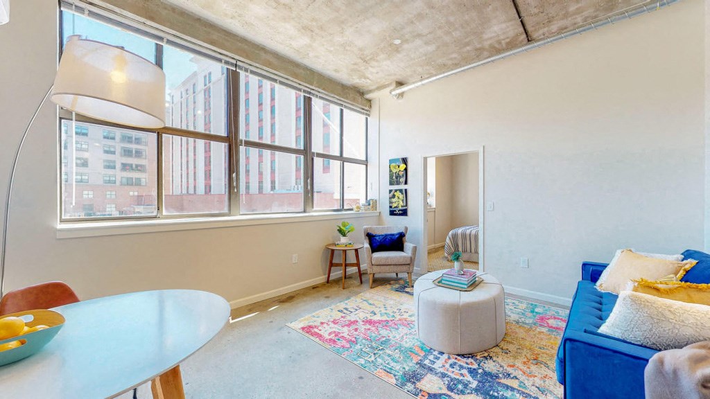 a living room with a large window and a blue couch