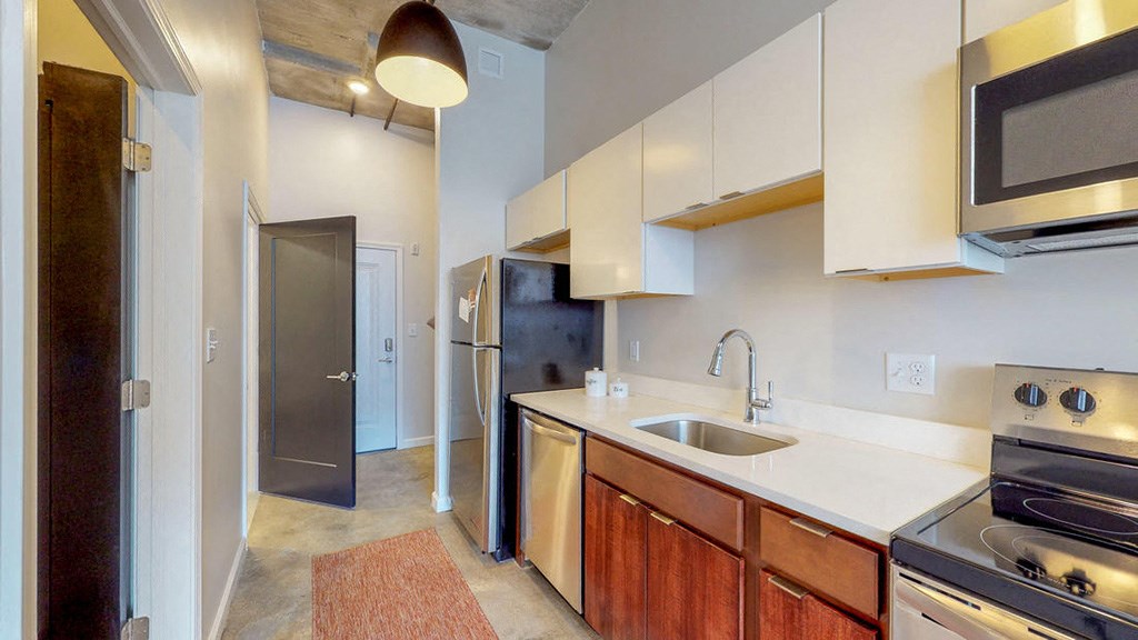 a kitchen with a sink and a door to a hallway