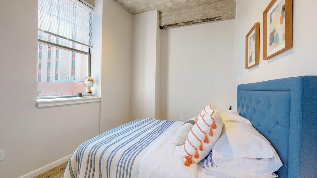 a bedroom with a bed and a window