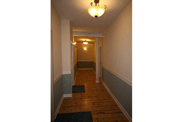 a long hallway with a light on the ceiling and a door