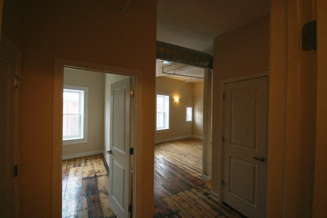 an empty living room and dining room with wood floors