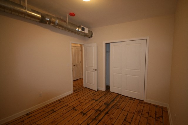 an empty room with a wooden floor and a white door