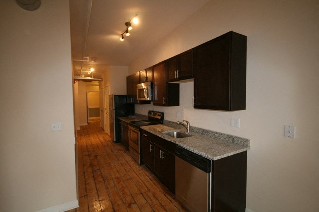 an empty kitchen with a sink and a counter top