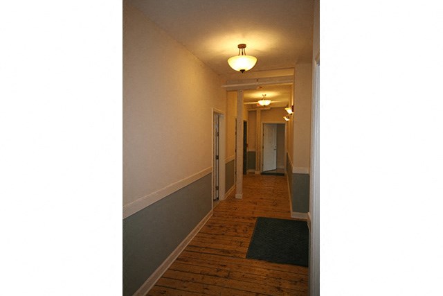a long hallway with wood floors and a light on the ceiling