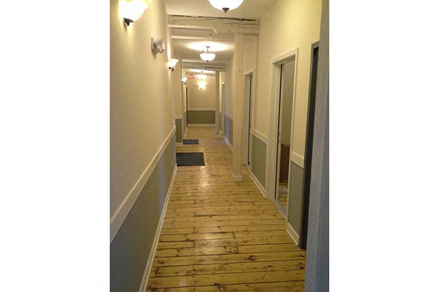 a long hallway with wooden floors and doors