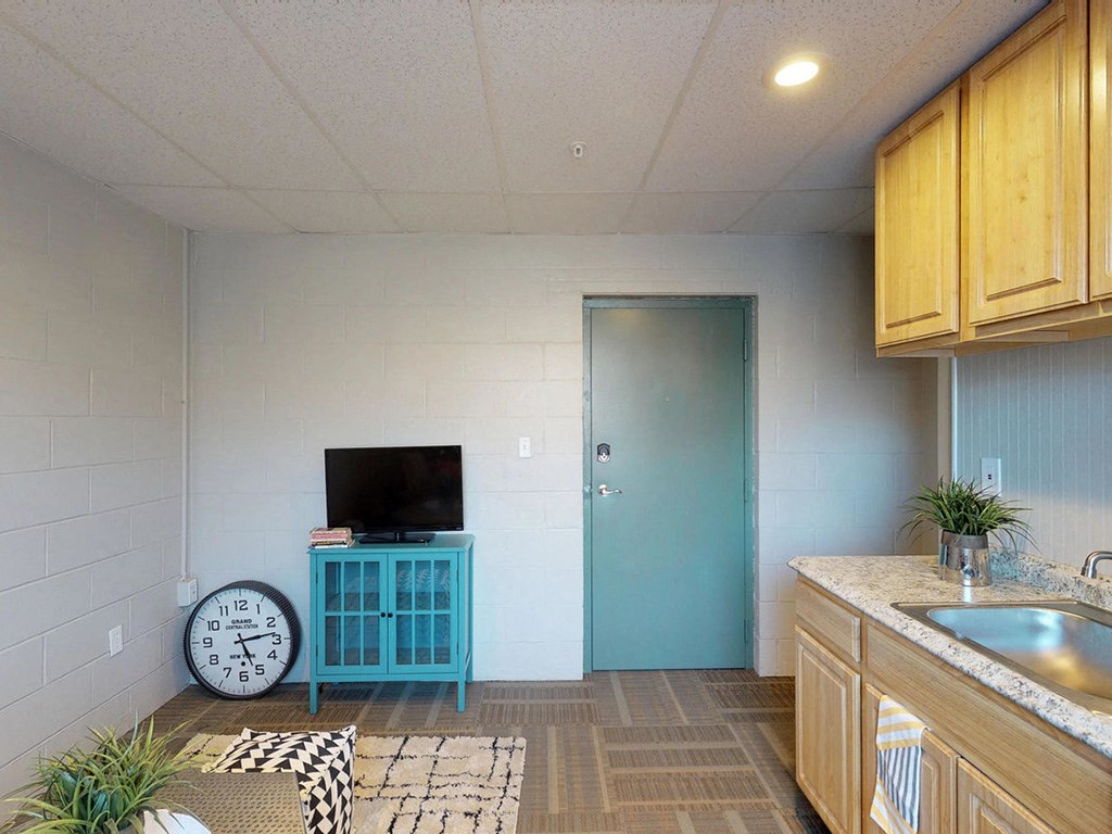 an empty room with a clock and a tv