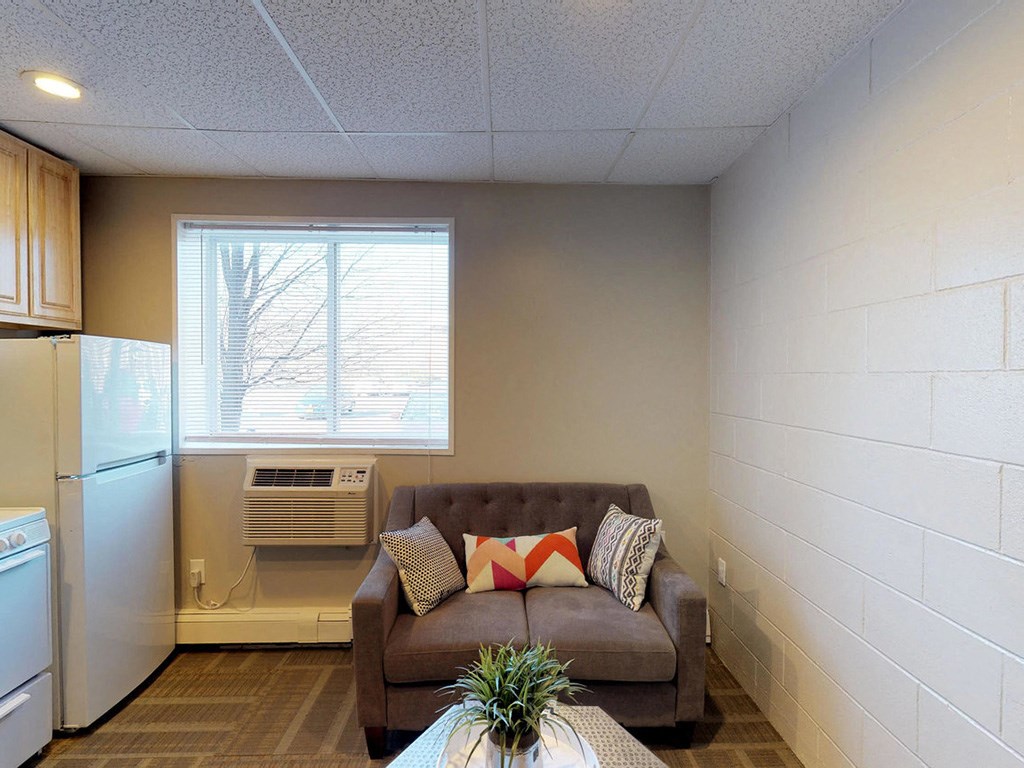 a living room with a couch and a refrigerator