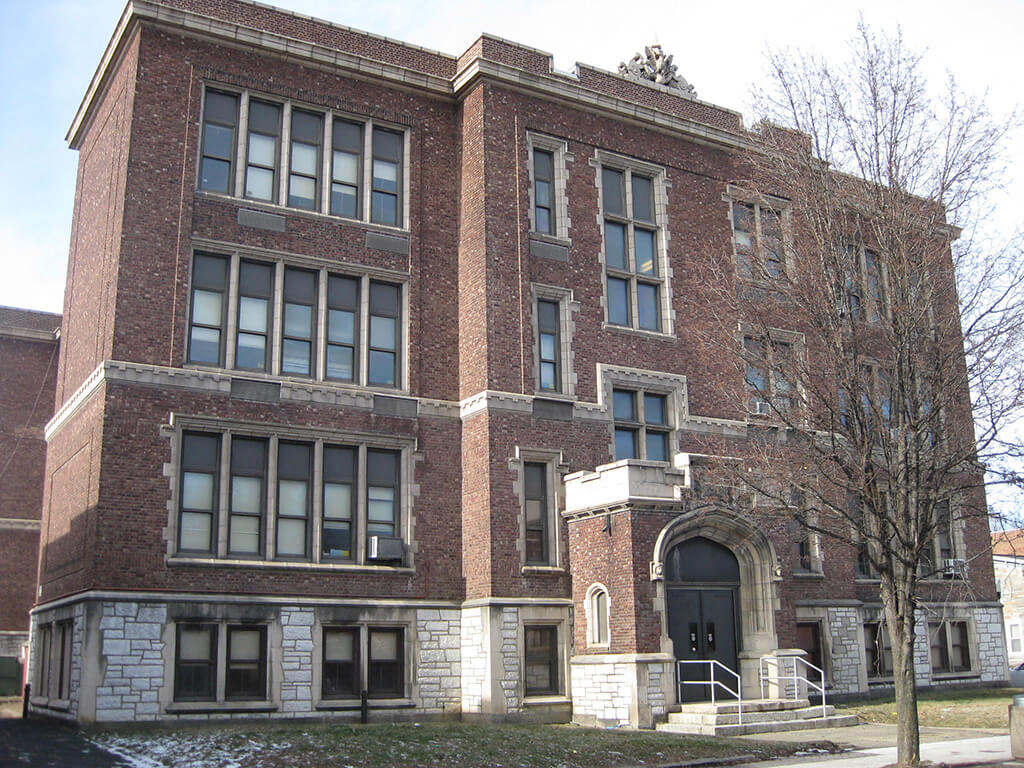 a large brick building with a tree in front of it