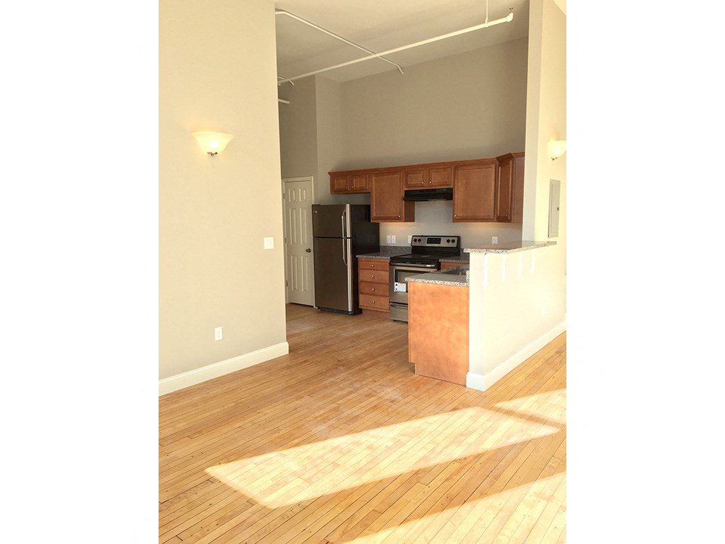 a view of a kitchen and a living room with wood floors