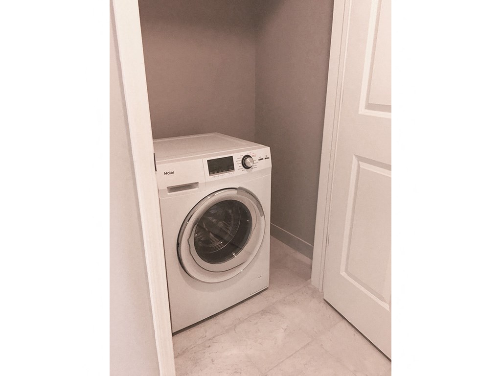 a washer and dryer in a closet with a door