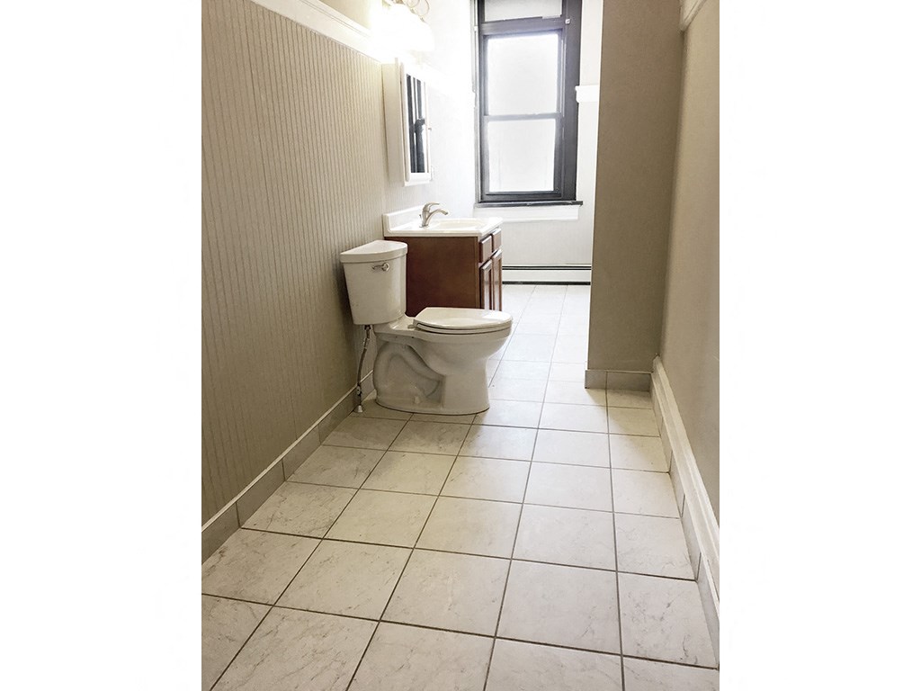 a bathroom with a toilet and a window