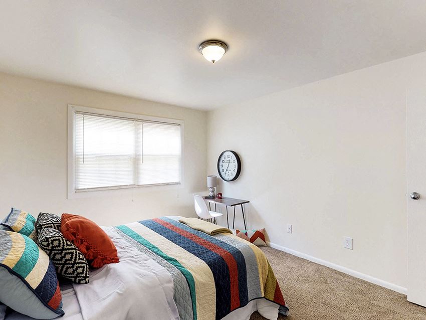 a bedroom with a bed and a clock on the wall