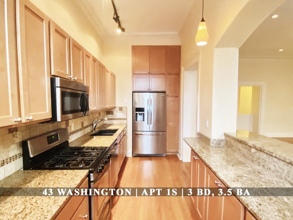 an updated kitchen with stainless steel appliances and marble counter tops