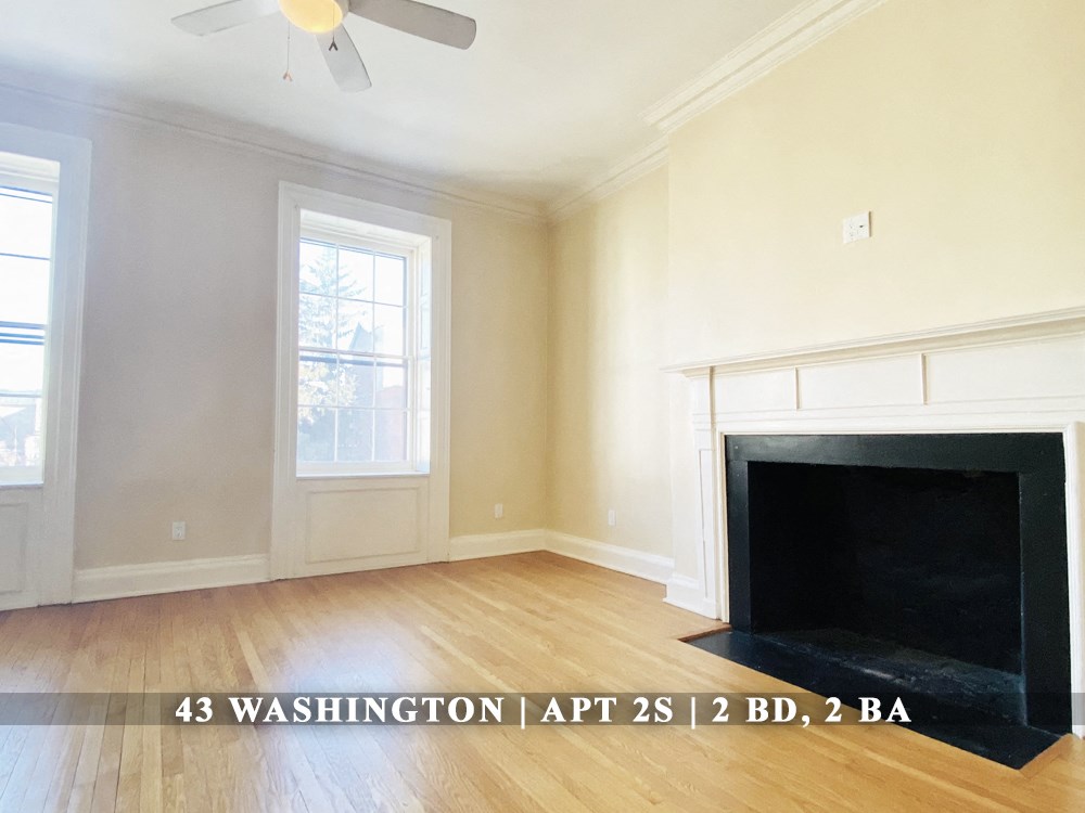 the view of a living room with wood floors and a fireplace