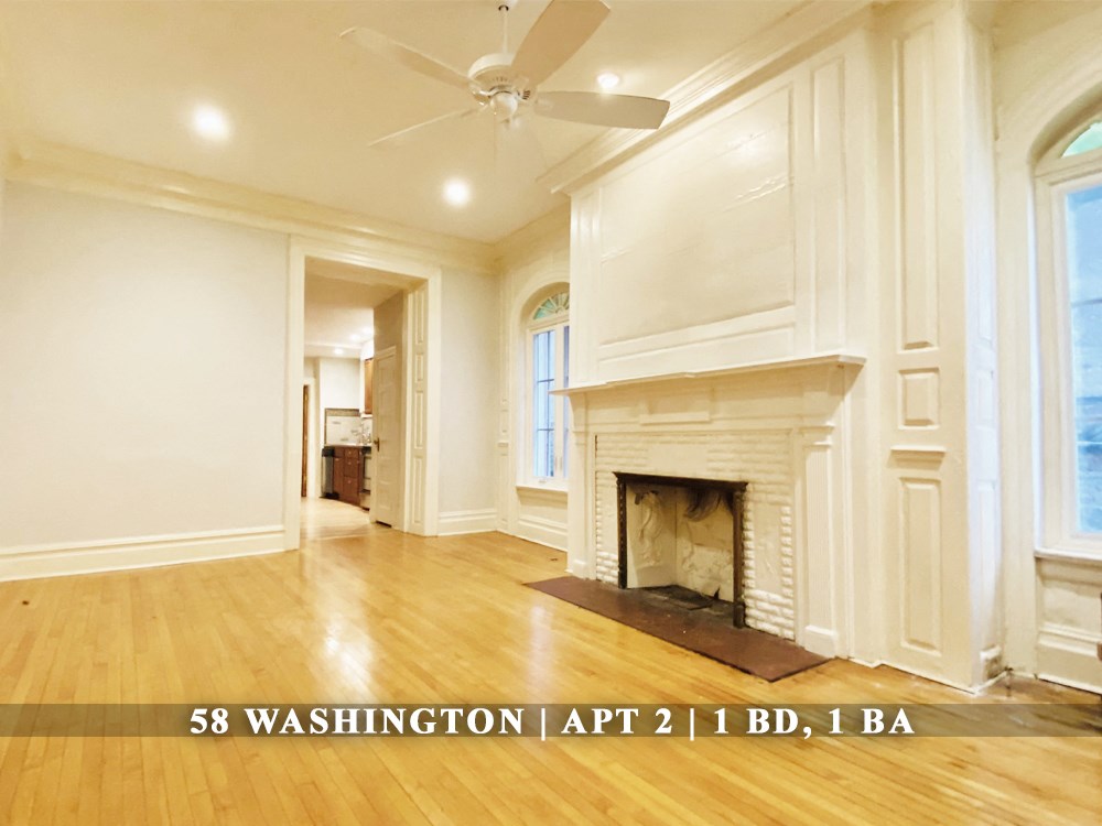 a living room with a fireplace and a wooden floor