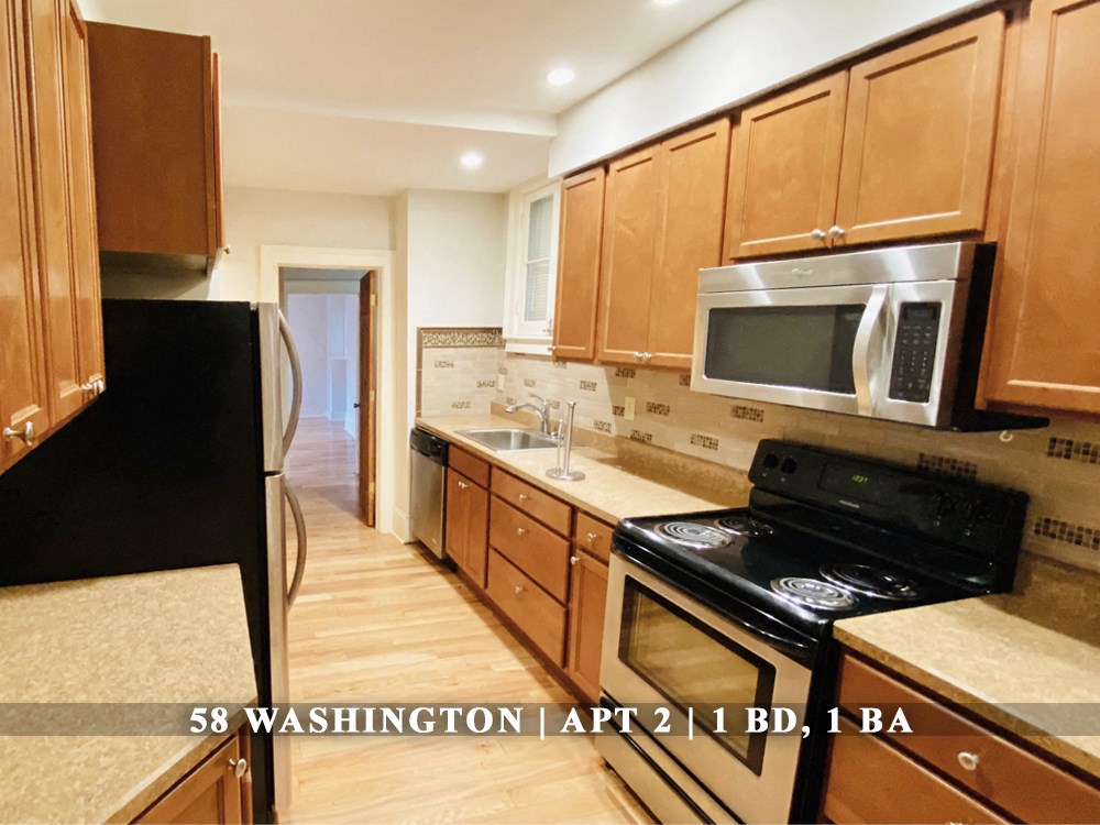 full interior view of a kitchen with wooden cabinets and stainless steel appliances