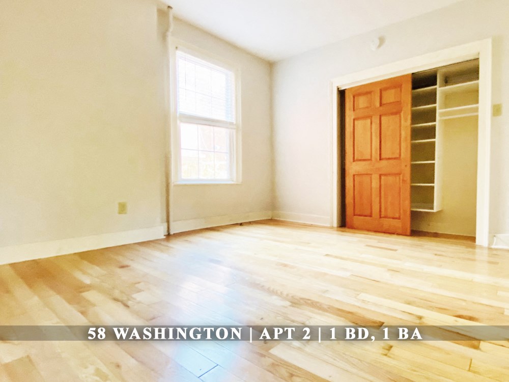 an empty room with a wooden floor and a wooden door