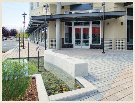 the front of a building with a water fountain in front