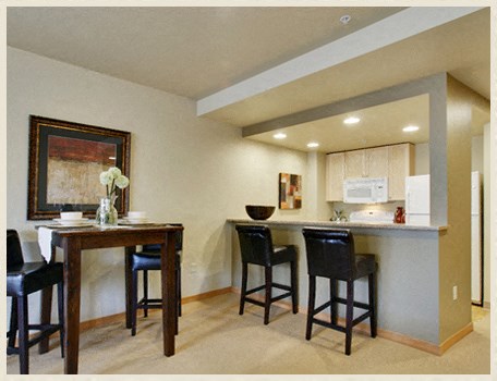 a kitchen with a bar and a dining table