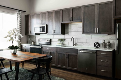 a kitchen with wooden cabinets and a wooden table
