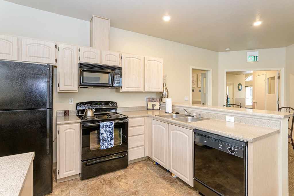 a kitchen with black appliances and white cabinets