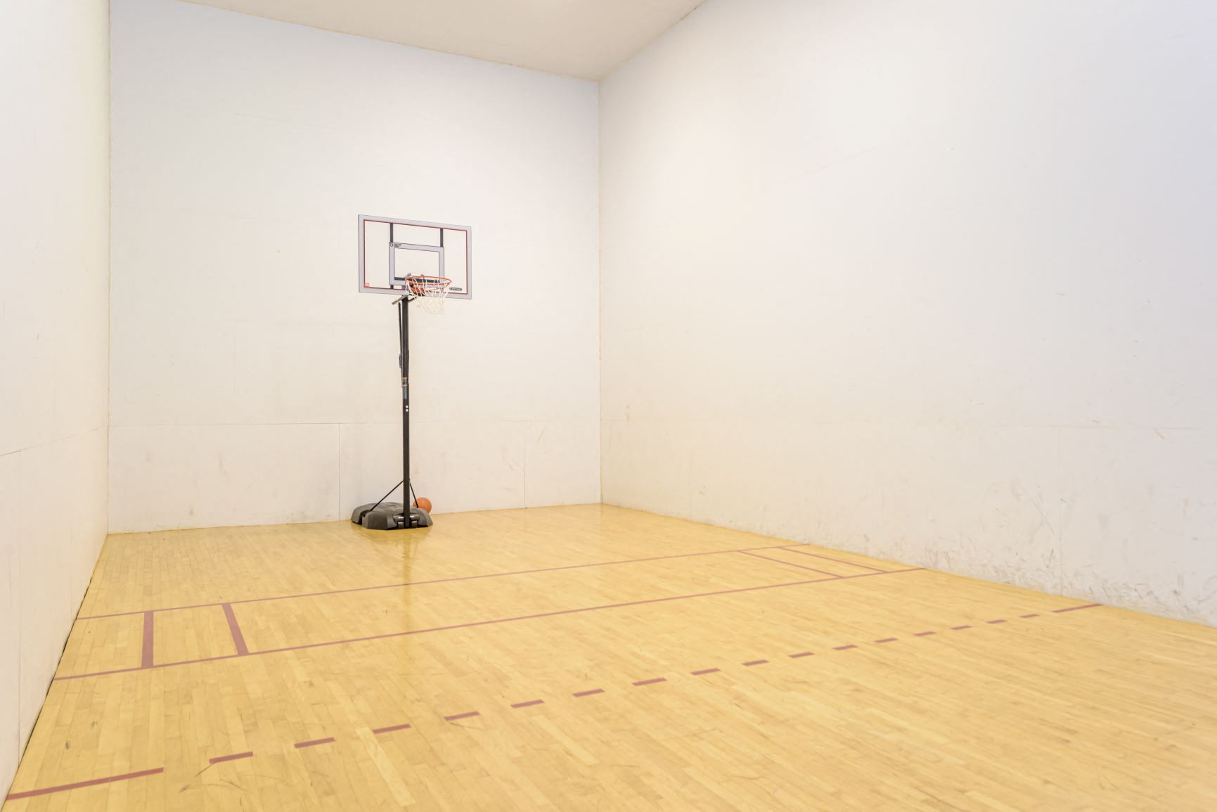 a basketball court in a white room with a basketball hoop on top of it