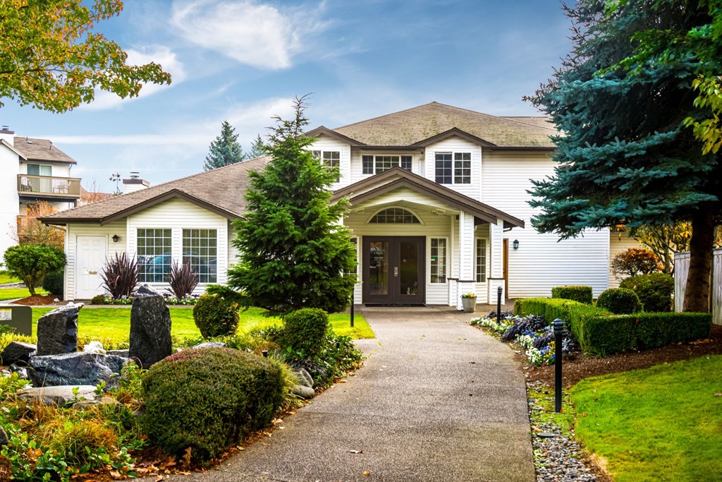 a large white house with a sidewalk in front of it