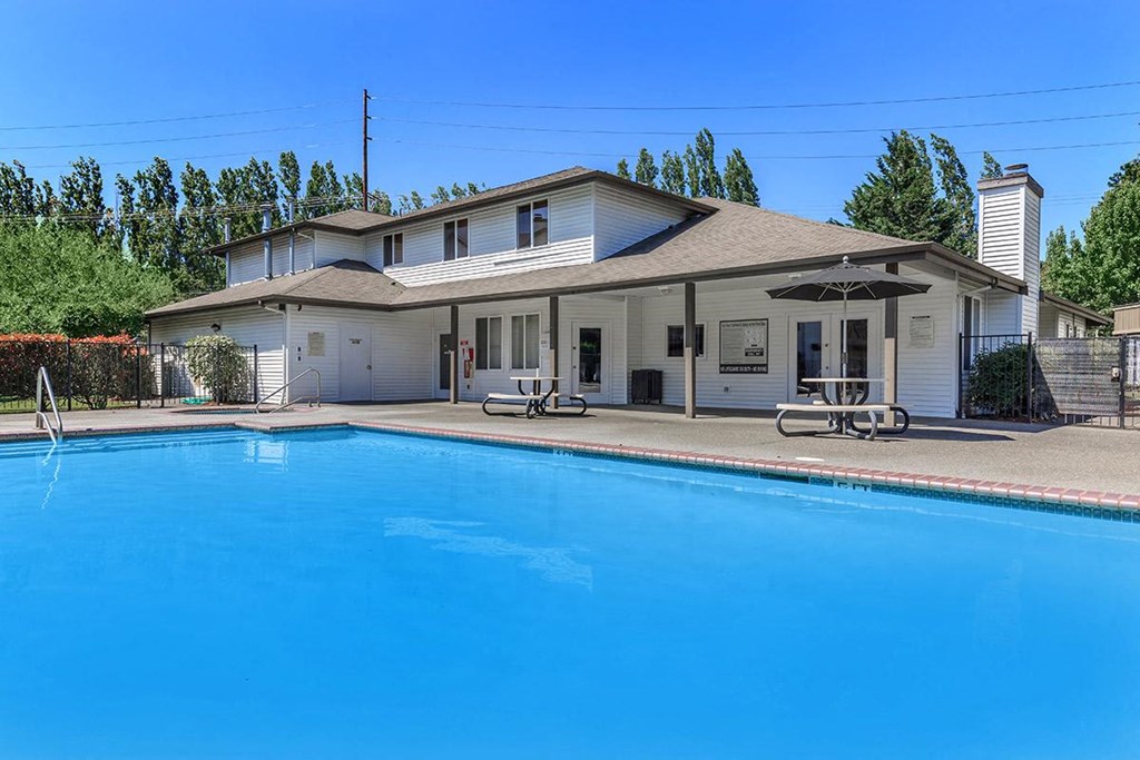 a large swimming pool in front of a white house