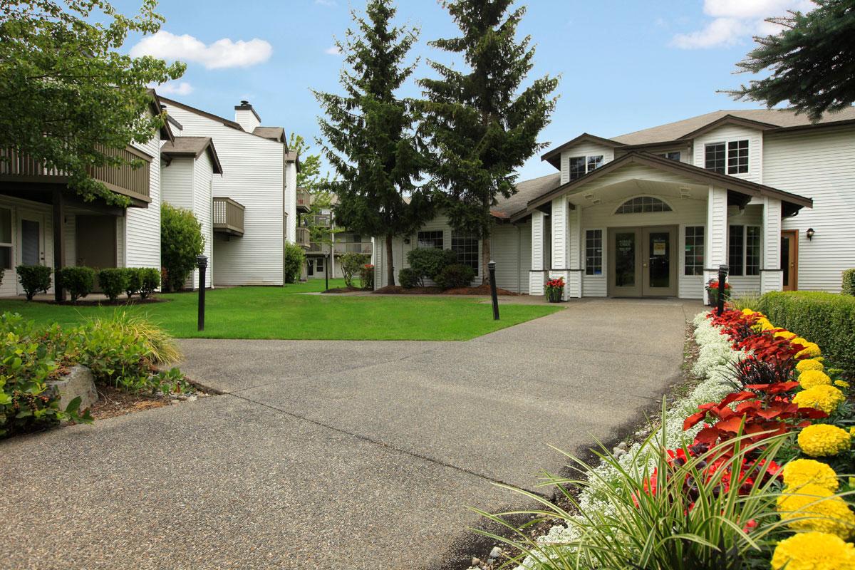 the front of a house with a driveway and a lawn