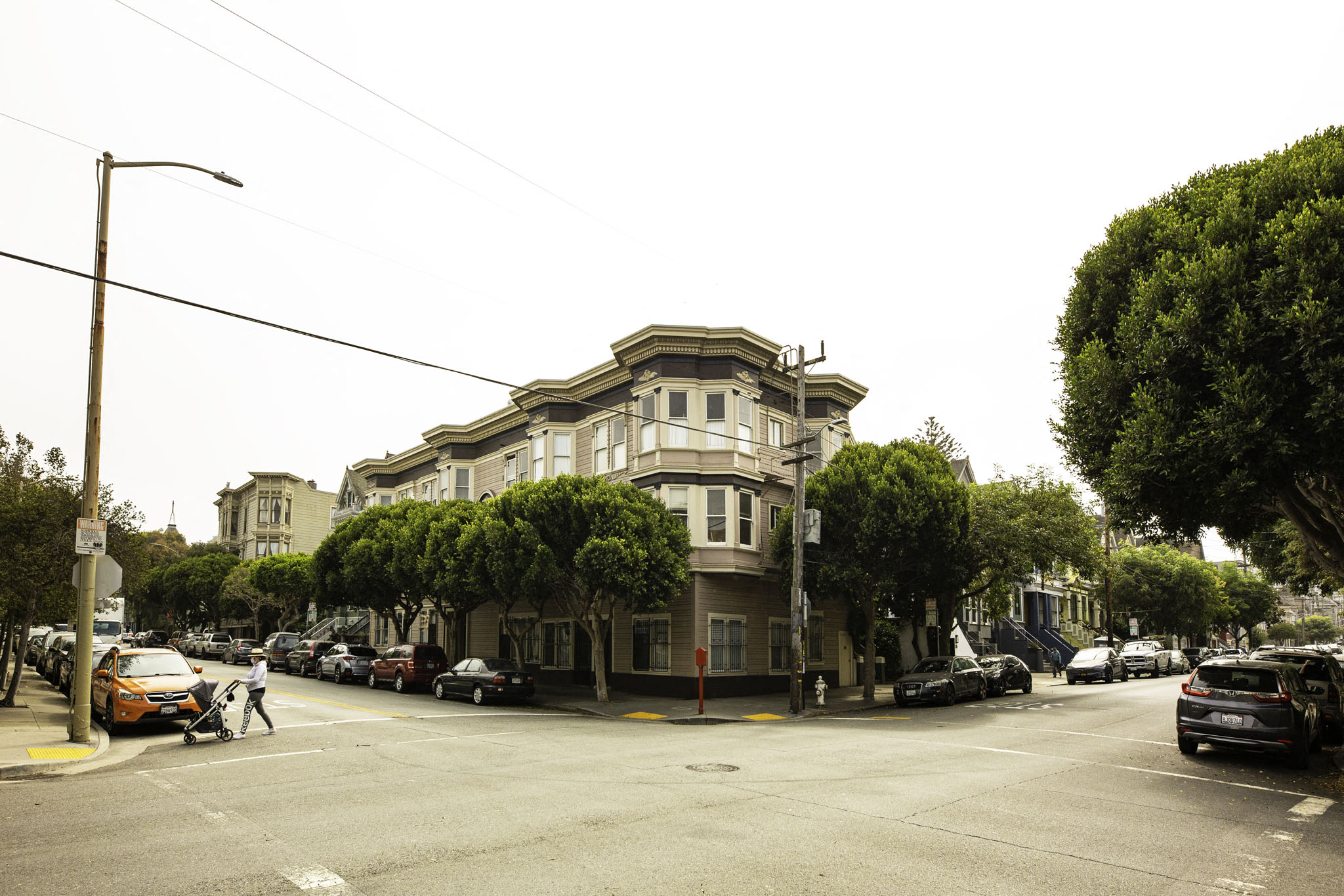 A street view of a building with cars parked in front.